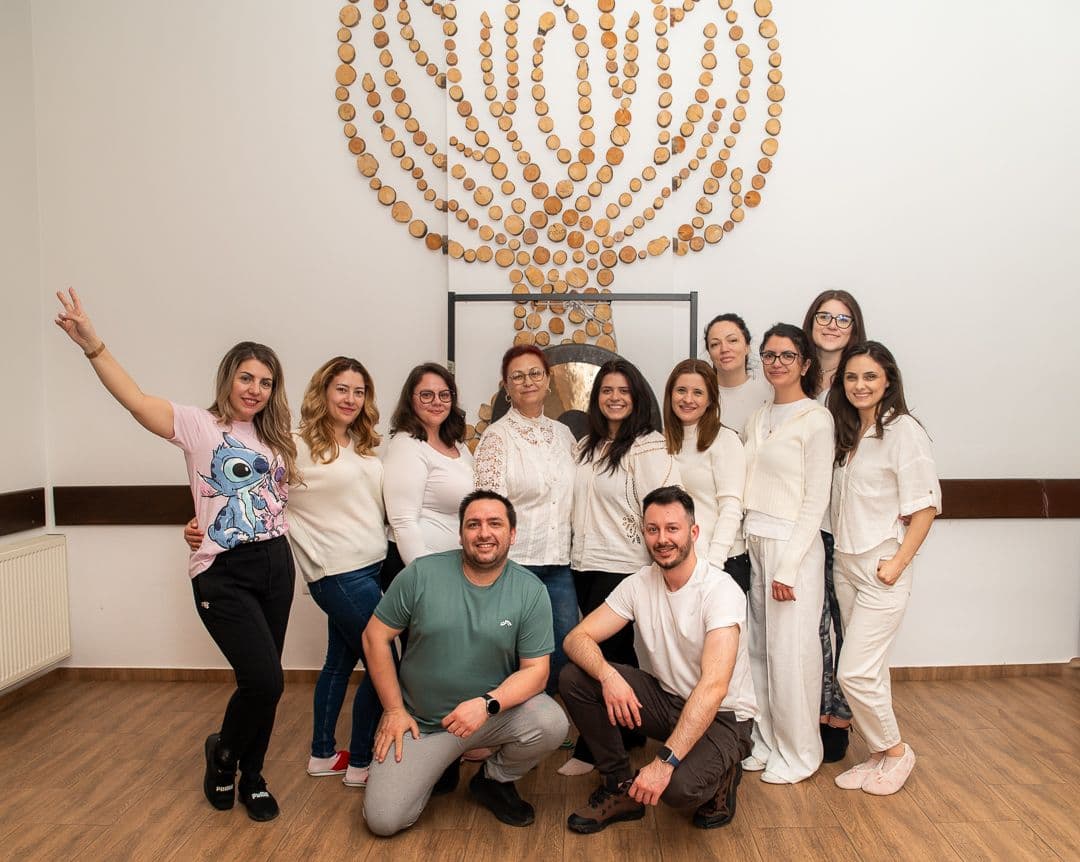 Grup de participanți la un workshop de sound healing, în fața unui gong