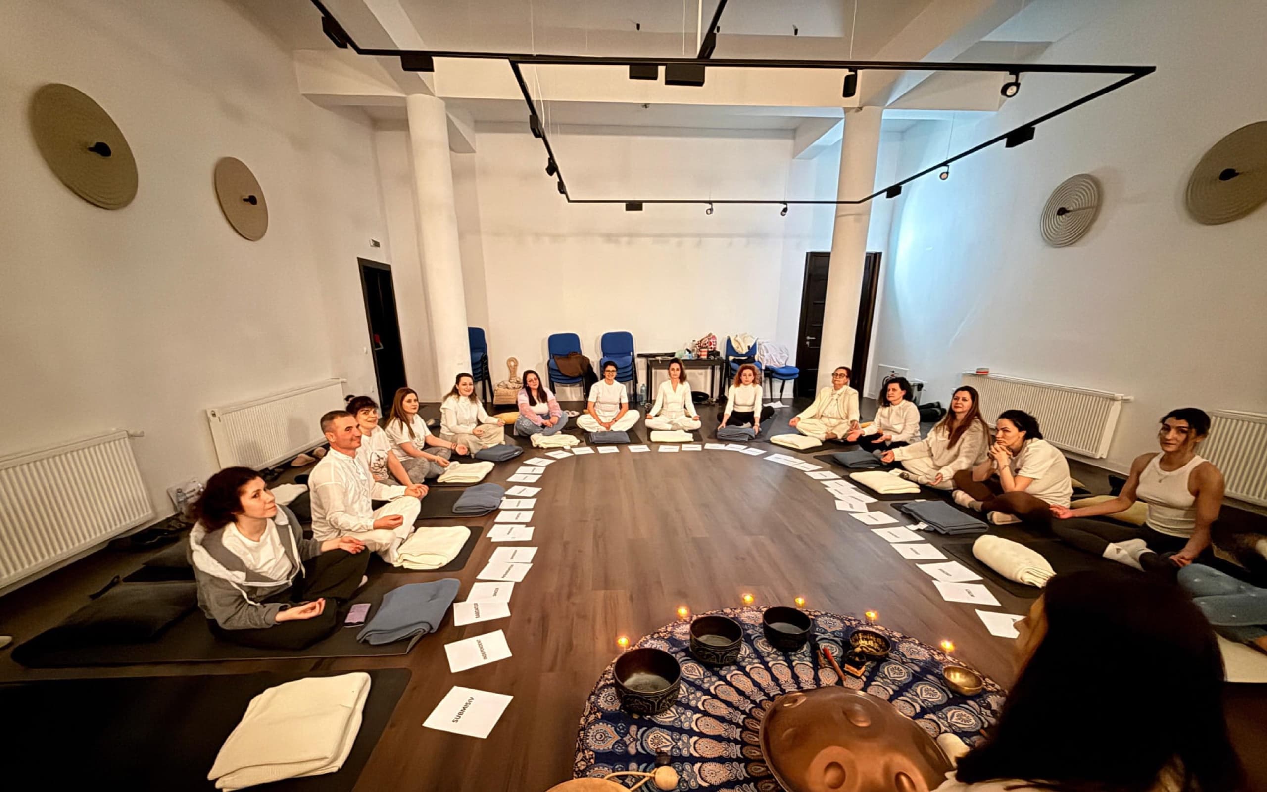 Grup așezat în cerc la o sesiune de sound bath